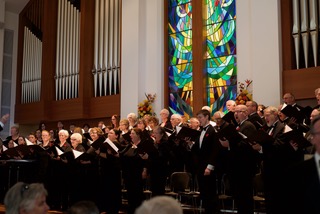 a choir in a large church with stained glass windows